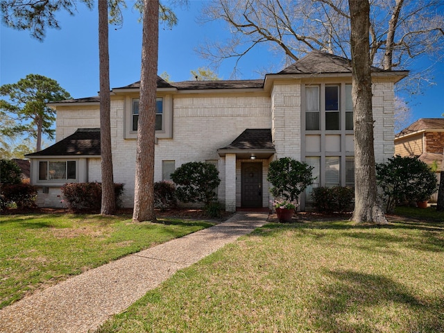 view of front of home featuring a front lawn and brick siding