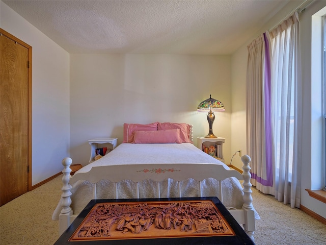 bedroom featuring baseboards, carpet floors, and a textured ceiling