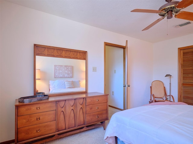 bedroom with light carpet, visible vents, baseboards, and a ceiling fan