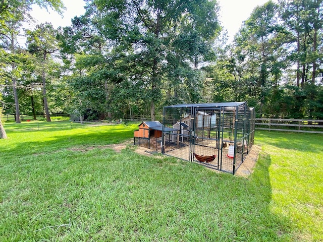 view of yard featuring an outbuilding, fence, and exterior structure