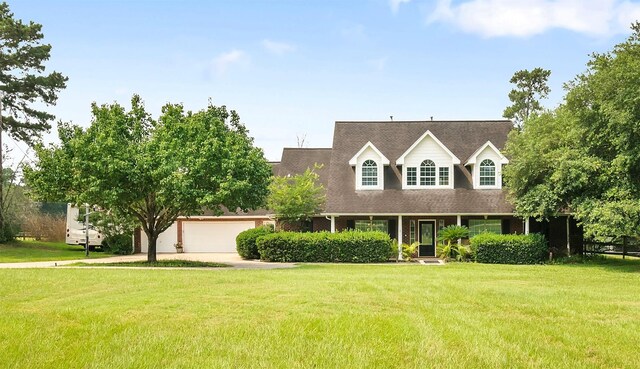 cape cod house with driveway, a front lawn, and an attached garage