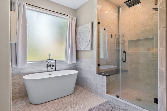 full bath featuring a soaking tub, plenty of natural light, tile walls, and a shower stall