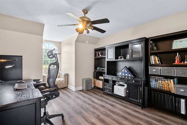 office area featuring ceiling fan, a textured ceiling, vaulted ceiling, and wood finished floors