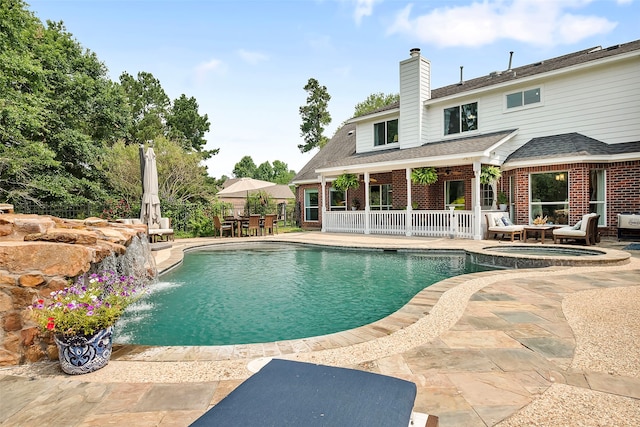 view of pool with a patio area, a pool with connected hot tub, and outdoor dining space