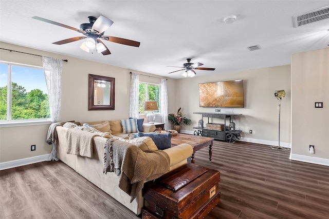 living area with visible vents, baseboards, and wood finished floors