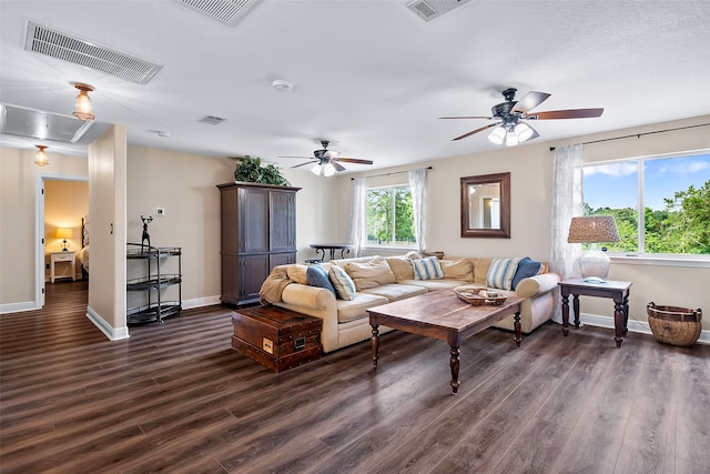 living room featuring dark wood finished floors, visible vents, and attic access