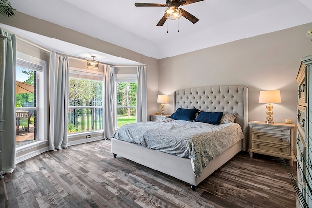 bedroom with ceiling fan, multiple windows, and dark wood-style flooring