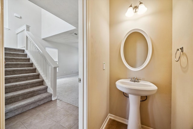 bathroom with baseboards and tile patterned floors