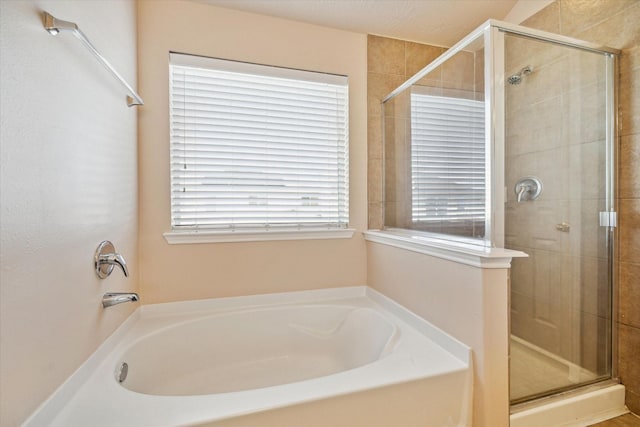 full bath featuring a stall shower and a garden tub