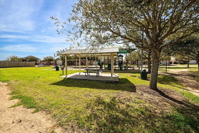 view of home's community featuring playground community, a lawn, and fence