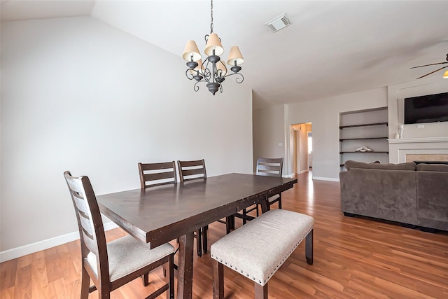 dining space with lofted ceiling, visible vents, baseboards, and wood finished floors