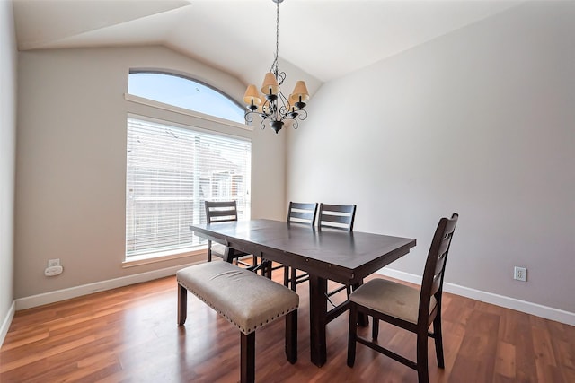 dining room featuring vaulted ceiling, light wood-type flooring, a notable chandelier, and baseboards