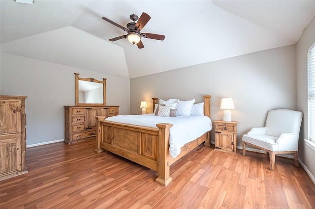 bedroom with light wood-style floors, lofted ceiling, and baseboards