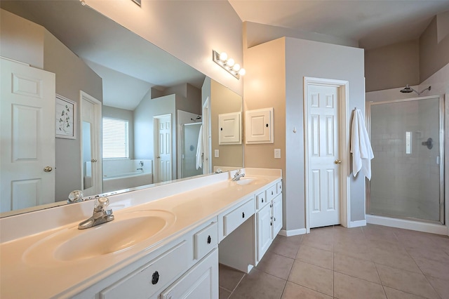 bathroom featuring double vanity, a stall shower, tile patterned floors, a garden tub, and a sink