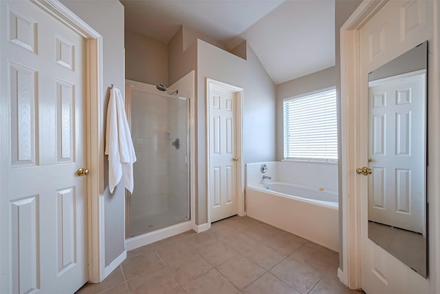 bathroom featuring vaulted ceiling, a stall shower, a garden tub, and tile patterned floors