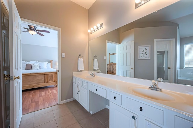 ensuite bathroom with double vanity, ensuite bath, a sink, and tile patterned floors