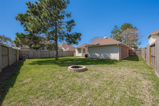 view of yard with a fire pit and a fenced backyard