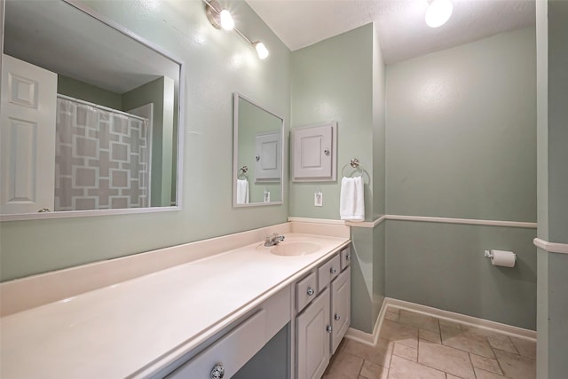 full bath featuring a shower with curtain, vanity, and baseboards