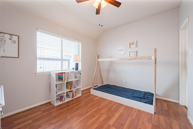 bedroom with vaulted ceiling, wood finished floors, a ceiling fan, and baseboards