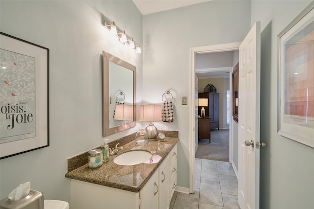 bathroom with toilet, tile patterned flooring, vanity, and baseboards