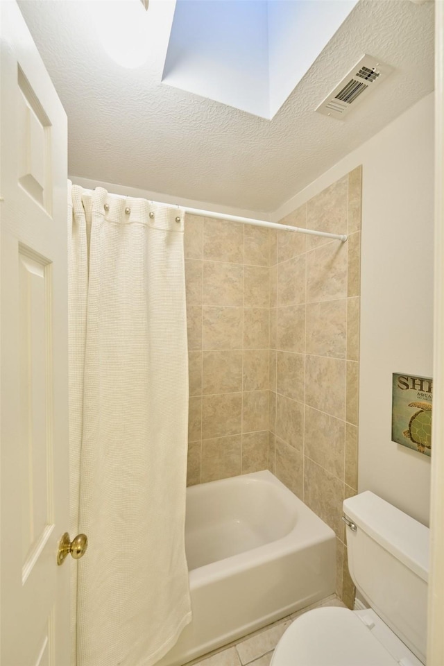 bathroom with a textured ceiling, toilet, visible vents, tile patterned floors, and shower / tub combo with curtain