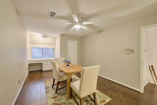 dining room featuring dark wood-style floors, visible vents, baseboards, and a ceiling fan