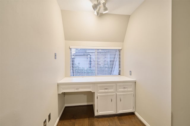 interior space with baseboards, vaulted ceiling, and wood finished floors