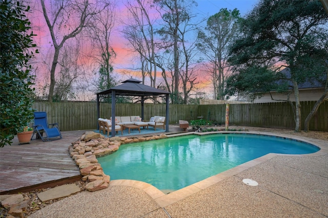 pool at dusk with a fenced in pool, a fenced backyard, outdoor lounge area, and a gazebo