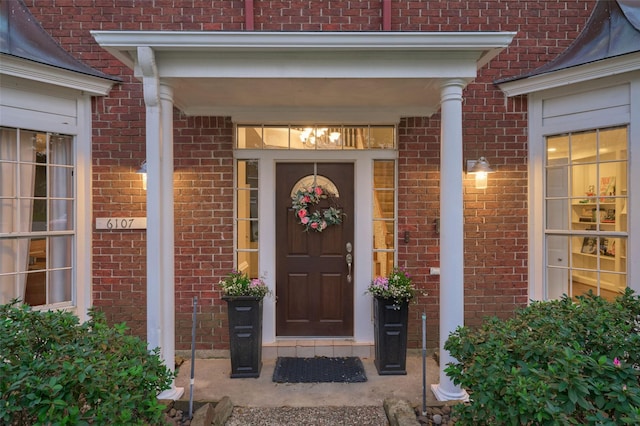 view of exterior entry featuring brick siding