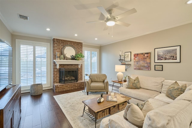 living area with visible vents, dark wood-style floors, crown molding, a fireplace, and recessed lighting