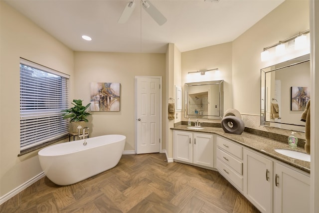 bathroom featuring baseboards, a sink, a freestanding bath, and double vanity