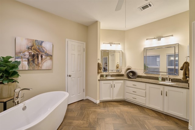 full bath with double vanity, a soaking tub, visible vents, and a sink