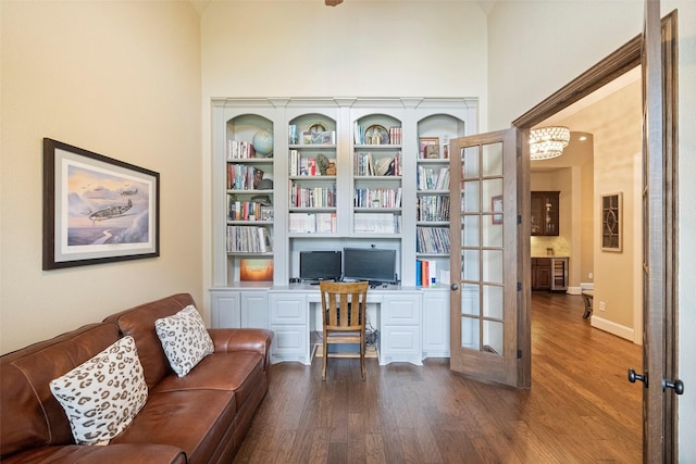 interior space featuring dark wood-style floors, built in study area, and baseboards