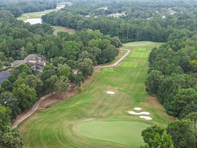 bird's eye view with a wooded view and view of golf course