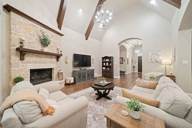 living room with arched walkways, high vaulted ceiling, beam ceiling, and wood finished floors