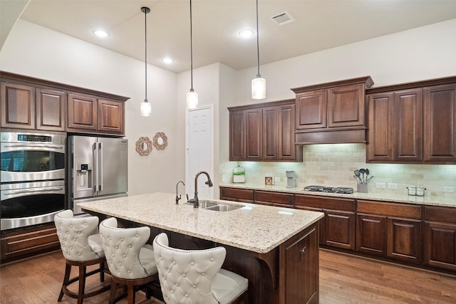 kitchen featuring a sink, visible vents, backsplash, and stainless steel appliances