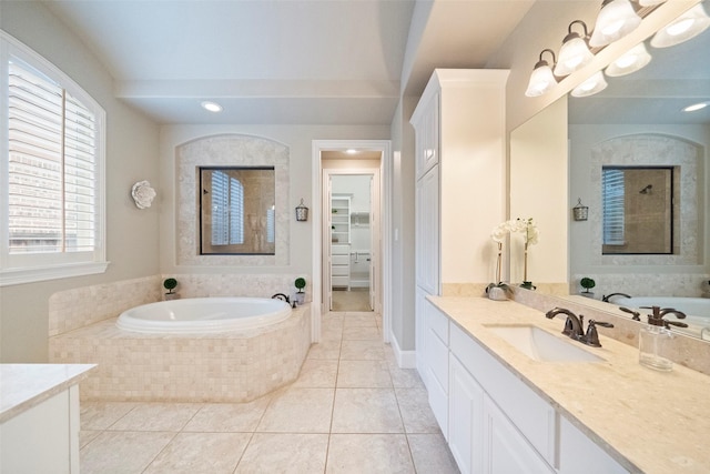 full bath with vanity, a walk in closet, a bath, and tile patterned flooring