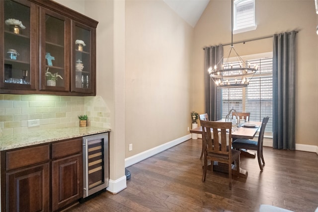 dining space featuring wine cooler, dark wood-style floors, baseboards, and a chandelier