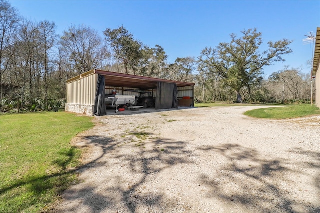 view of pole building featuring a carport, a lawn, and driveway