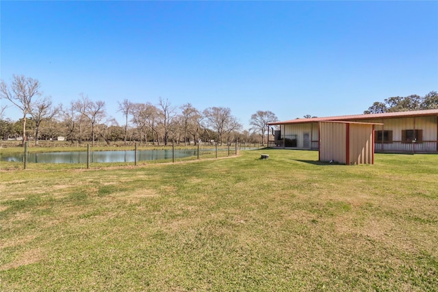 view of yard featuring an outbuilding, a pole building, and a water view