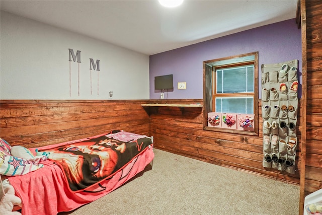 bedroom with a wainscoted wall, carpet, and wooden walls