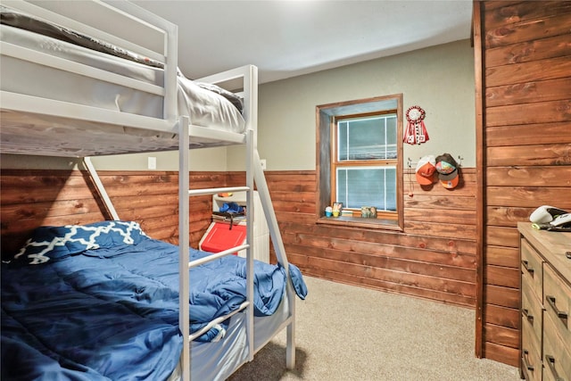 carpeted bedroom featuring a wainscoted wall and wooden walls