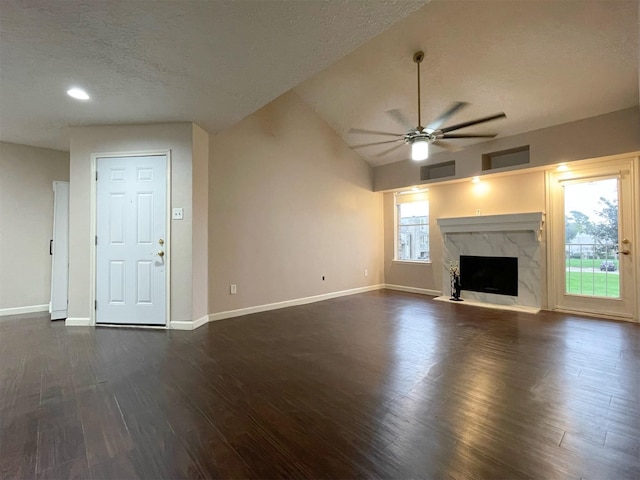 unfurnished living room featuring dark wood-style floors, a ceiling fan, a high end fireplace, a textured ceiling, and baseboards