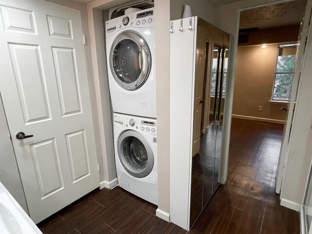 laundry room featuring laundry area, baseboards, dark wood-style floors, and stacked washer and clothes dryer