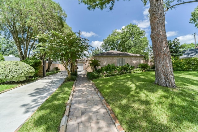 view of front of house featuring brick siding, a front yard, fence, and a gate