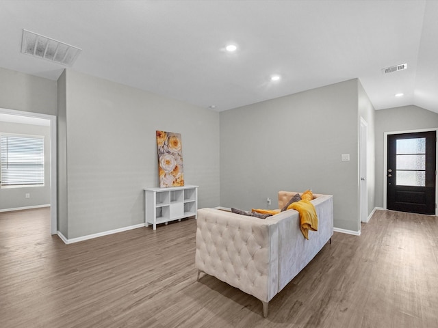 living area featuring a wealth of natural light, visible vents, and wood finished floors