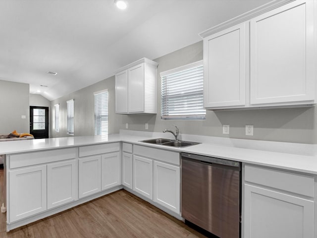 kitchen featuring a sink, stainless steel dishwasher, a peninsula, and light countertops