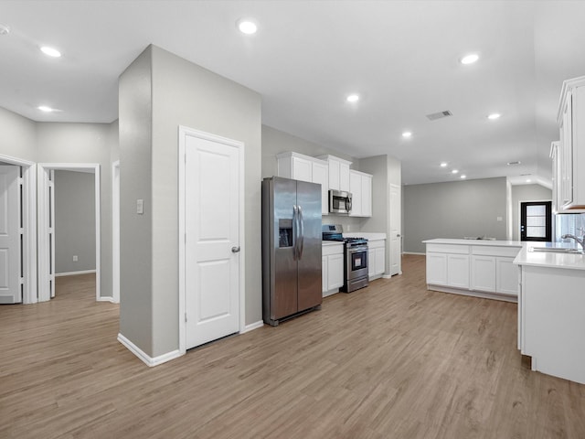 kitchen with light wood finished floors, visible vents, white cabinetry, and stainless steel appliances