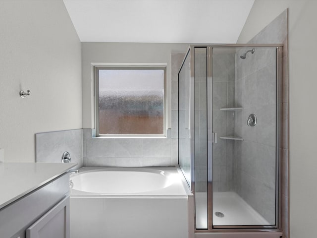 full bath featuring a garden tub, a stall shower, vanity, and vaulted ceiling