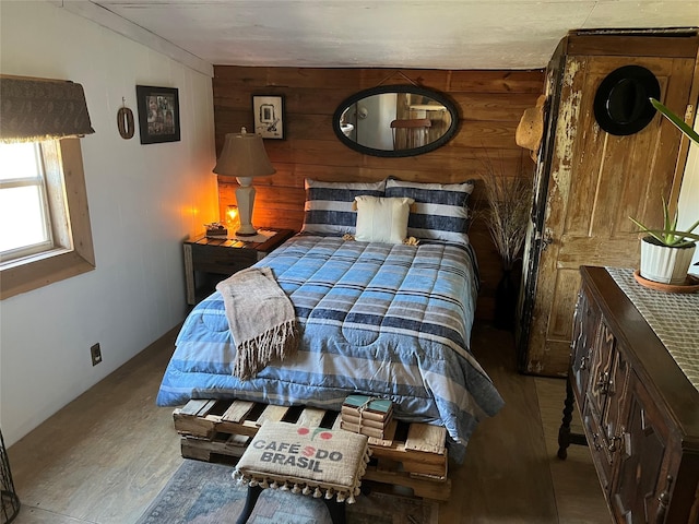 bedroom featuring wood finished floors and wooden walls